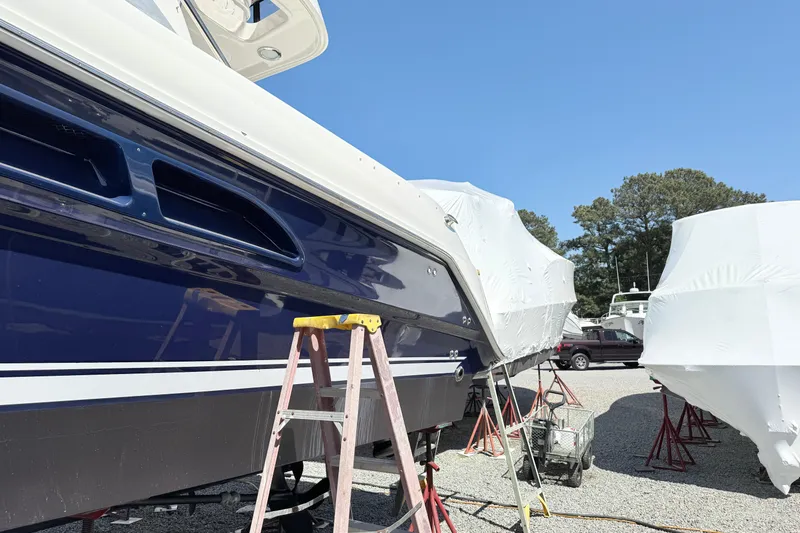 Slide: The Image of 2007 Sea Ray 44 Sedan Bridge yacht in dry dock, partially covered, with a ladder nearby. - 6