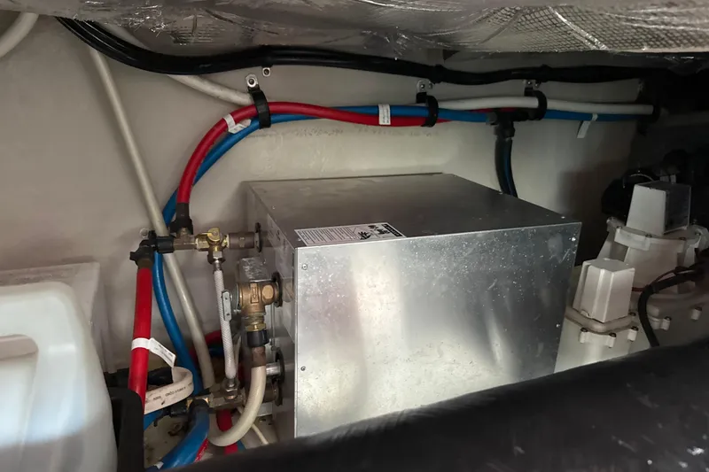 Slide: The Image of Engine compartment of 2007 Sea Ray 44 Sedan Bridge with visible plumbing and metal components. - 60