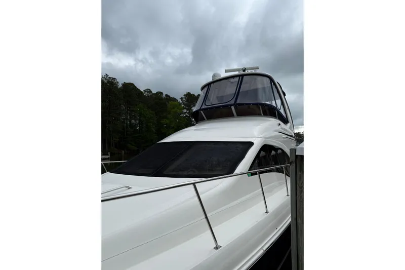 Slide: The Image of 2007 Sea Ray 44 Sedan Bridge yacht docked under cloudy skies. - 8