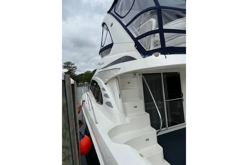 Slide: The Image of 2007 Sea Ray 44 Sedan Bridge yacht docked, featuring sleek design and spacious upper deck. - 9