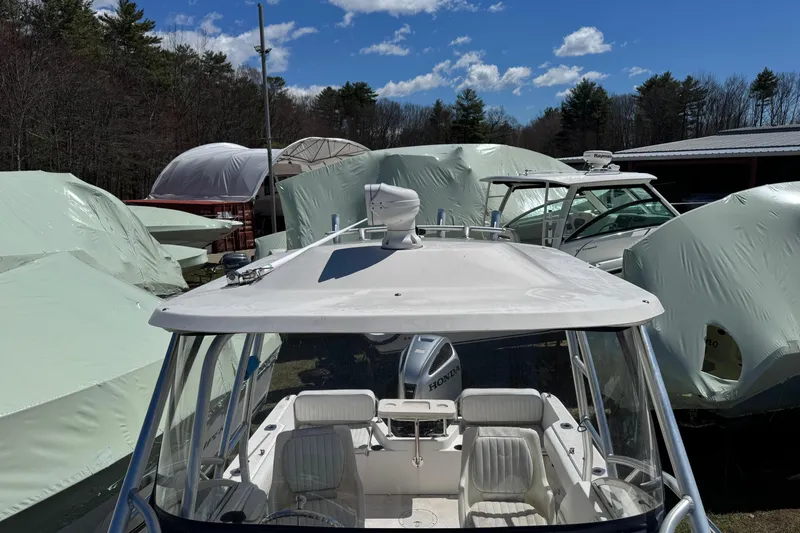 Slide: The Image of 2000 Boston Whaler 21 Conquest boat in storage, surrounded by covered vessels. - 10