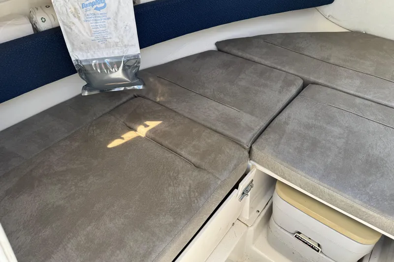 Slide: The Image of Interior cabin of 2000 Boston Whaler 21 Conquest with gray cushions and storage. - 13