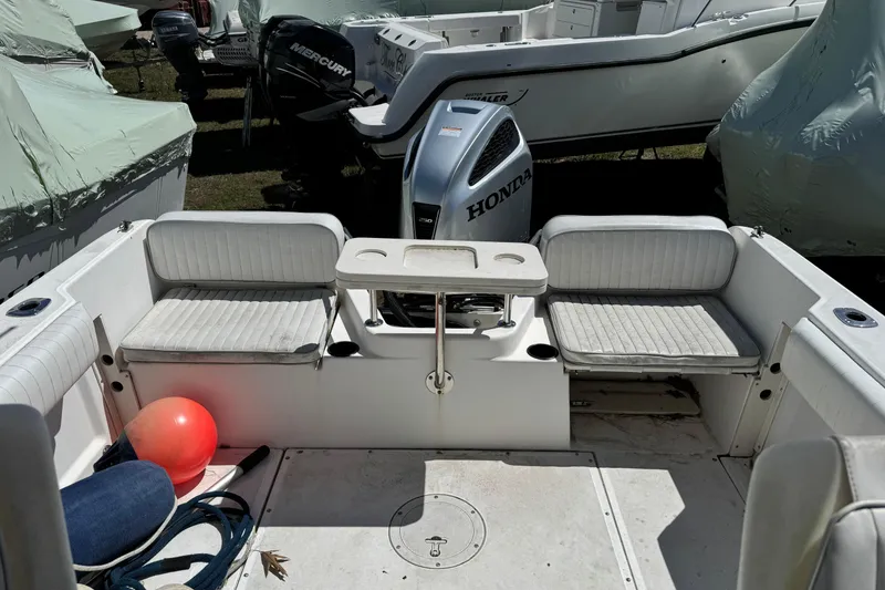 Slide: The Image of 2000 Boston Whaler 21 Conquest boat interior with seating and Honda outboard motor. - 16