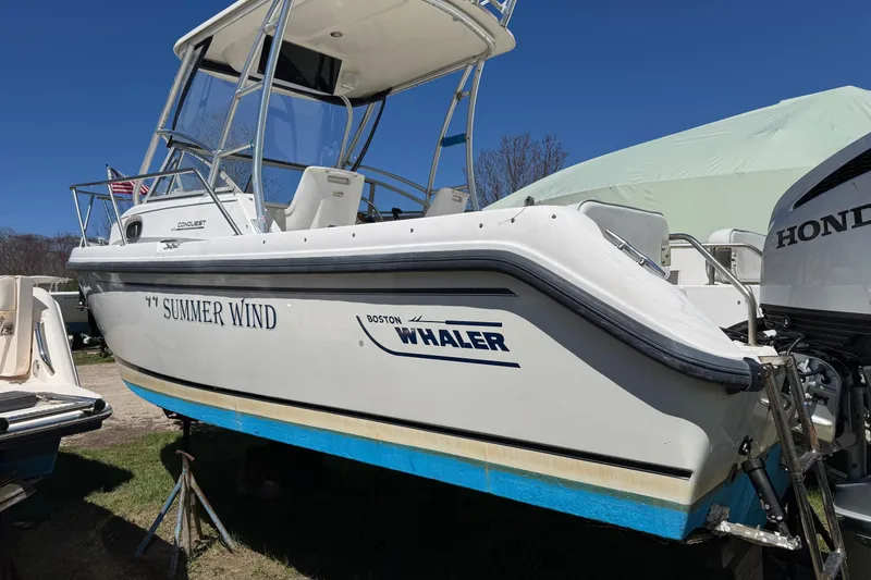 Slide: The Image of 2000 Boston Whaler 21 Conquest boat named "Summer Wind" on display outdoors. - 2