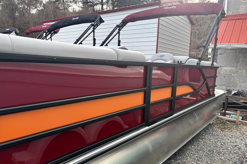 The Image of 2026 Bentley Pontoons Legacy 220 Navigator with red and orange accents, parked outdoors. - 0