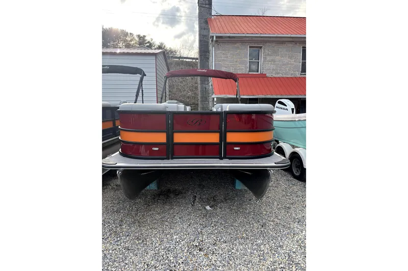 Slide: The Image of 2026 Bentley Pontoons Legacy 220 Navigator, red and orange, parked on gravel. - 2