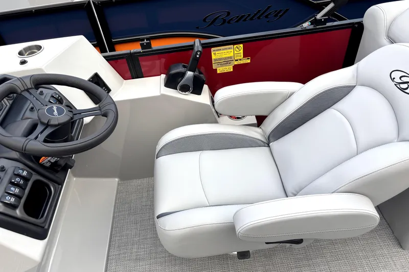 Slide: The Image of 2026 Bentley Pontoons Legacy 220 Navigator helm with luxurious captain's chair and steering console. - 9