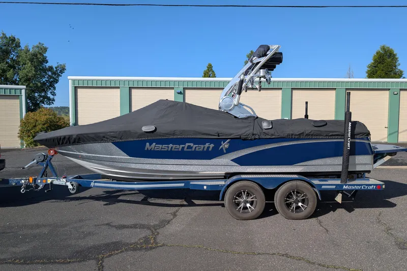 Slide: The Image of 2016 MasterCraft X10 boat on trailer, covered, parked outdoors. - 12
