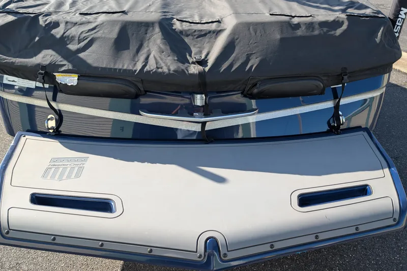 Slide: The Image of 2016 MasterCraft X10 boat with cover, rear view showing swim platform. - 15
