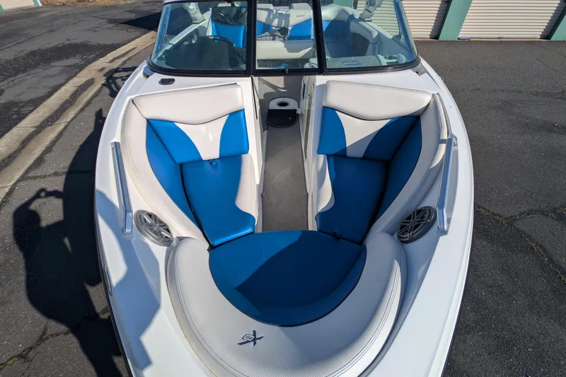 Slide: The Image of 2016 MasterCraft X10 boat with blue and white seating, docked on pavement. - 17