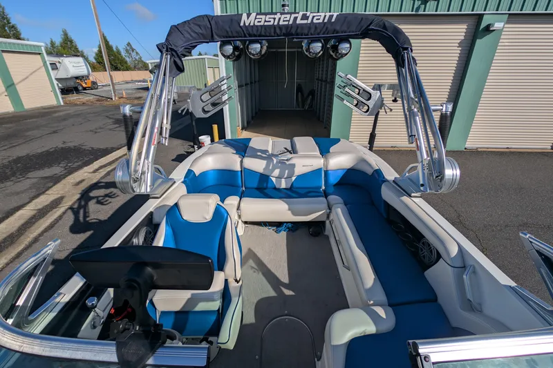 Slide: The Image of 2016 MasterCraft X10 boat interior with blue and white seating, docked near storage units. - 20