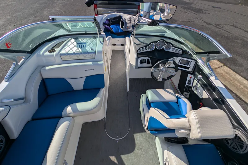 Slide: The Image of 2016 MasterCraft X10 boat interior with blue and white seating, dashboard, and steering wheel. - 22