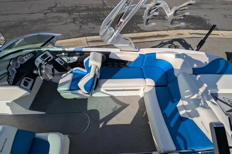 Slide: The Image of 2016 MasterCraft X10 boat interior with blue and white seating, sleek dashboard, and modern design. - 24