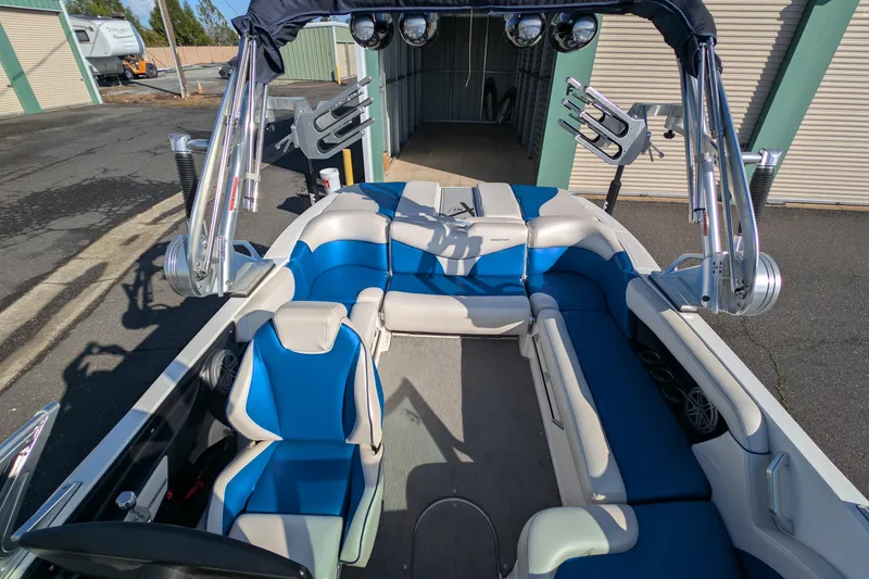 Slide: The Image of 2016 MasterCraft X10 boat interior with blue and white seating, docked outdoors. - 26