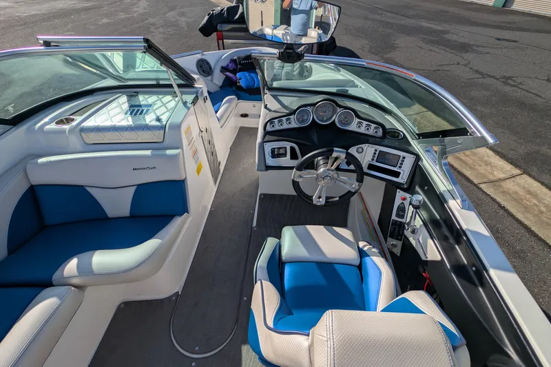 Slide: The Image of 2016 MasterCraft X10 boat interior with blue and white seating, modern dashboard, and steering wheel. - 28