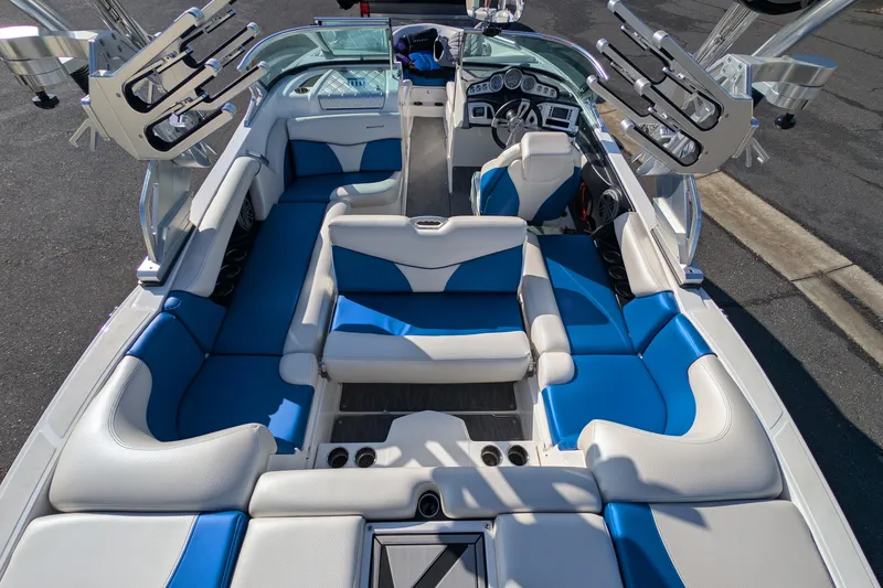 Slide: The Image of 2016 MasterCraft X10 boat interior with blue and white seating, featuring multiple cup holders. - 29