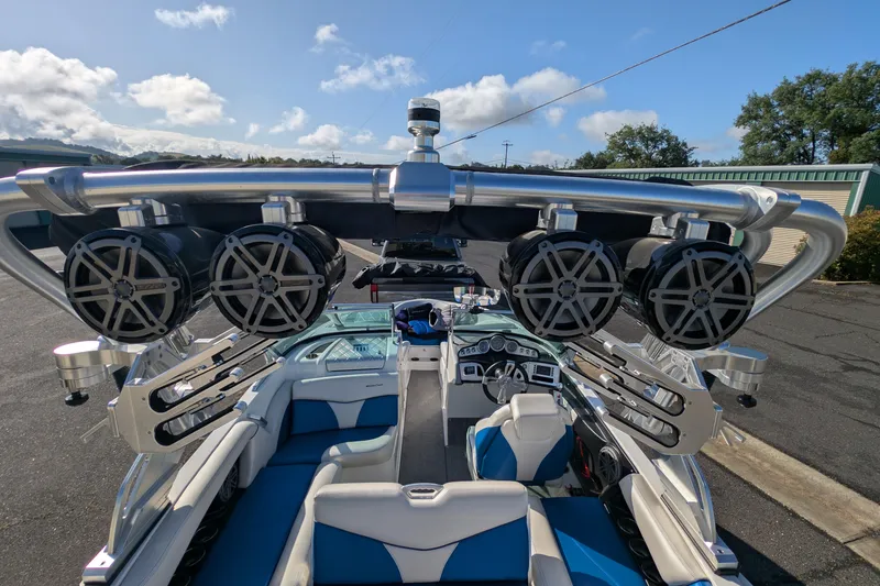 Slide: The Image of 2016 MasterCraft X10 boat interior with speakers and seating, under a clear sky. - 32
