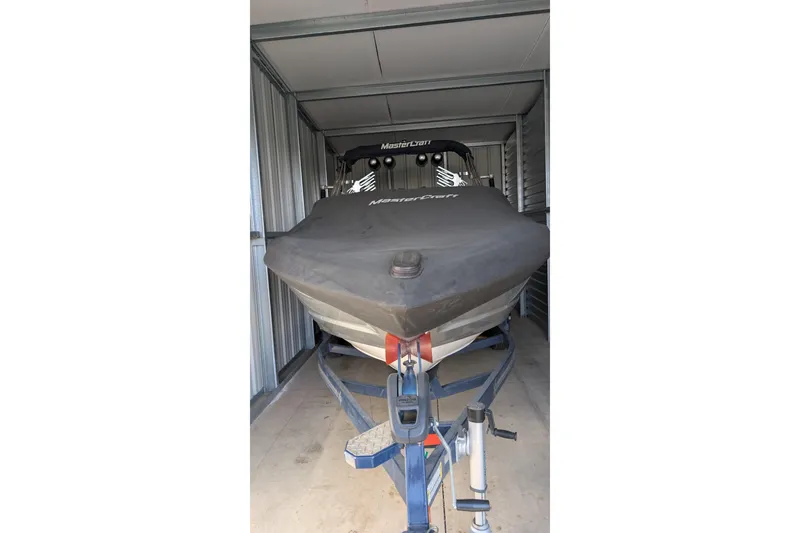 Slide: The Image of 2016 MasterCraft X10 boat stored in a metal garage on a trailer. - 46