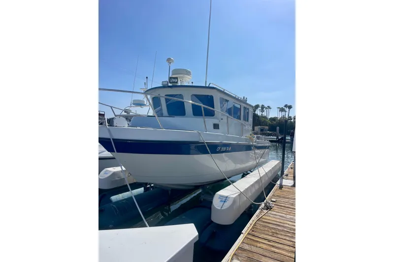 The Image of 2000 Davis Rock Harbor 25 LC boat docked at marina under clear blue sky. - 1