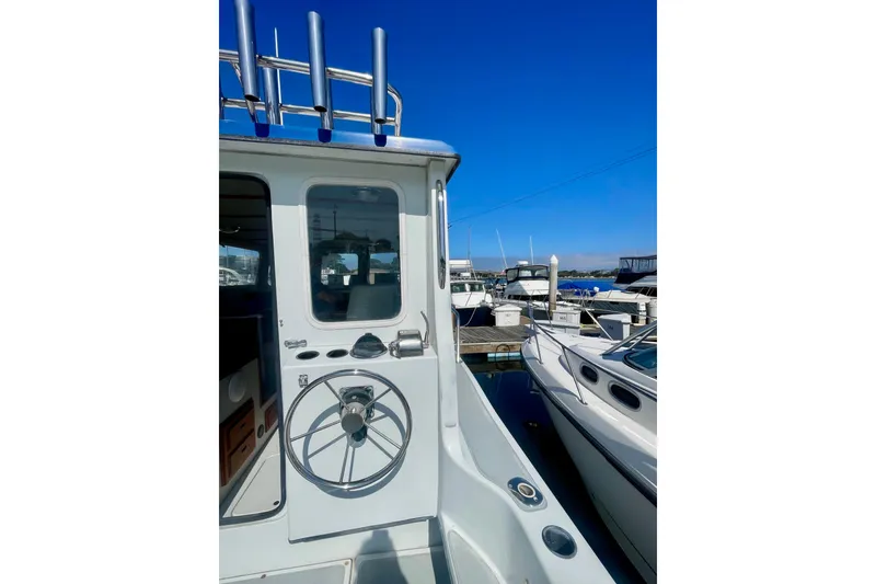 Slide: The Image of 2000 Davis Rock Harbor 25 LC boat docked under clear blue sky. - 10