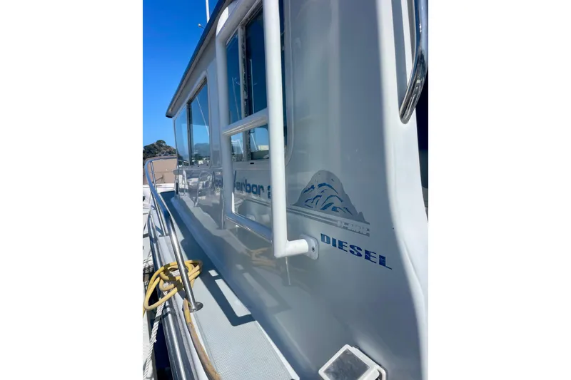 Slide: The Image of 2000 Davis Rock Harbor 25 LC boat deck with rope, docked among other vessels. - 5