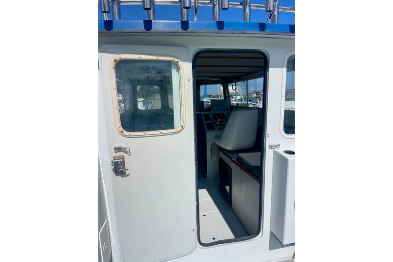 Slide: The Image of Interior of a 2000 Davis Rock Harbor 25 LC boat with seating and helm. - 8