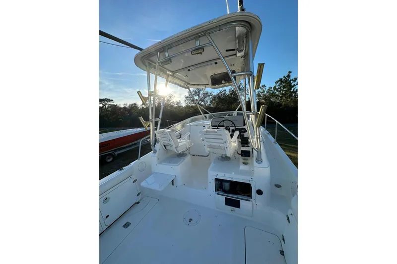 Slide: The Image of 2002 Century 2900 Walk-Around boat interior with helm and seating under a clear sky. - 10