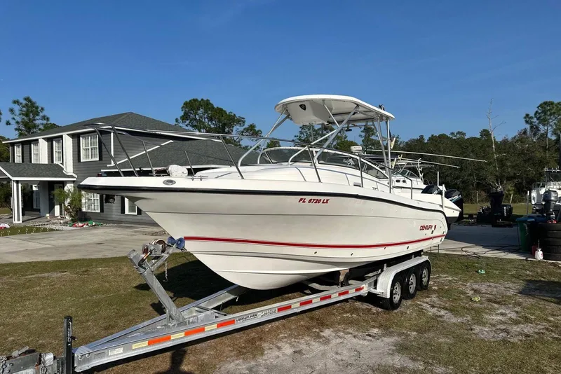 Slide: The Image of 2002 Century 2900 Walk-Around boat on trailer, parked near a house. - 14