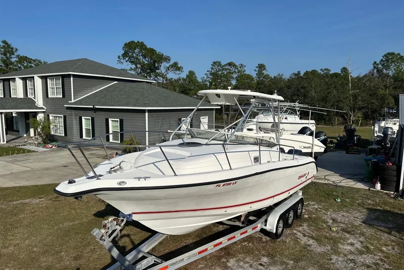 Slide: The Image of 2002 Century 2900 Walk-Around boat on trailer in residential driveway. - 15