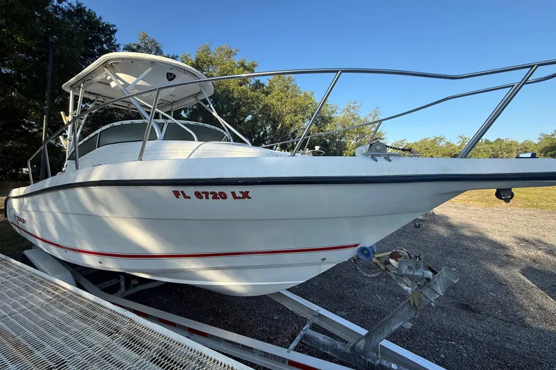 Slide: The Image of 2002 Century 2900 Walk-Around boat on trailer, parked outdoors under clear sky. - 22