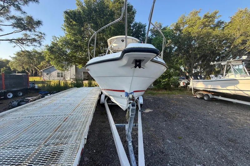 Slide: The Image of 2002 Century 2900 Walk-Around boat on trailer, surrounded by trees and other boats. - 24