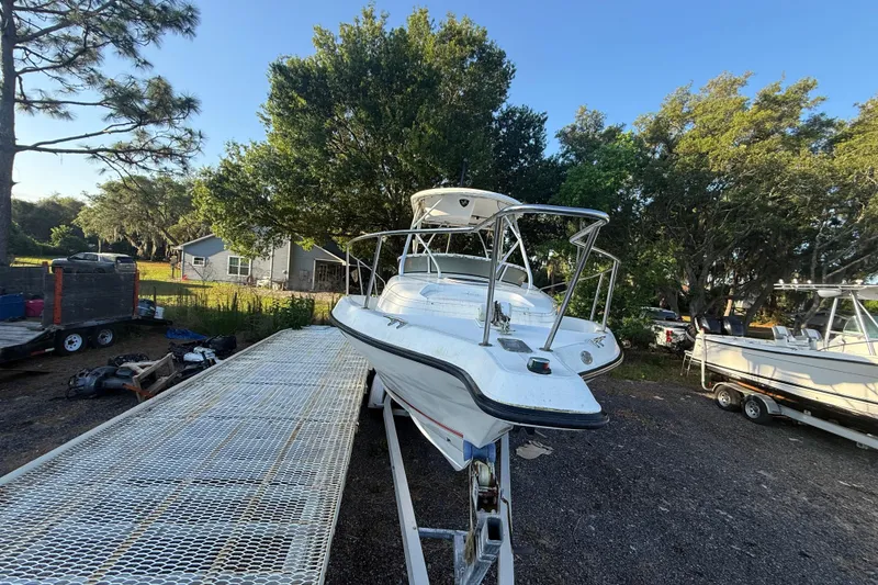 Slide: The Image of 2002 Century 2900 Walk-Around boat on trailer, surrounded by trees and equipment. - 26
