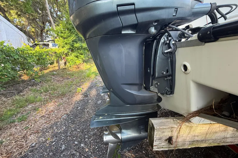Slide: The Image of Outboard motor of a 2002 Century 2900 Walk-Around boat, parked on gravel. - 31