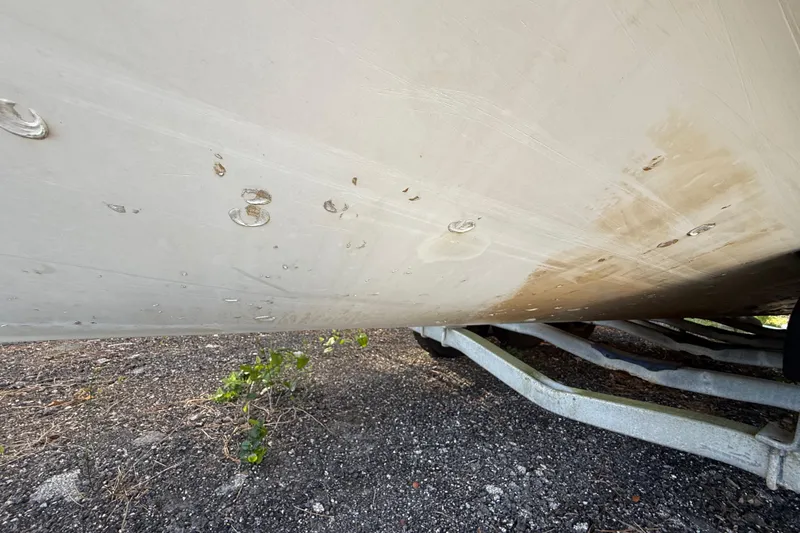 Slide: The Image of 2002 Century 2900 Walk-Around boat hull with visible wear and trailer underneath. - 39