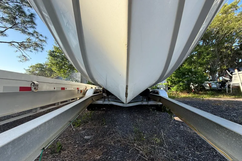 Slide: The Image of 2002 Century 2900 Walk-Around boat on trailer, viewed from below, surrounded by trees. - 41