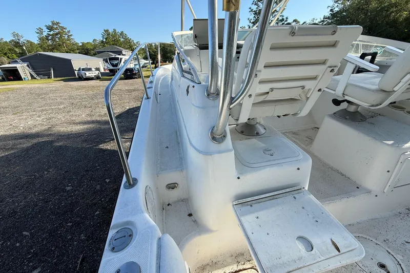 Slide: The Image of 2002 Century 2900 Walk-Around boat interior with seating and railing, parked outdoors. - 52
