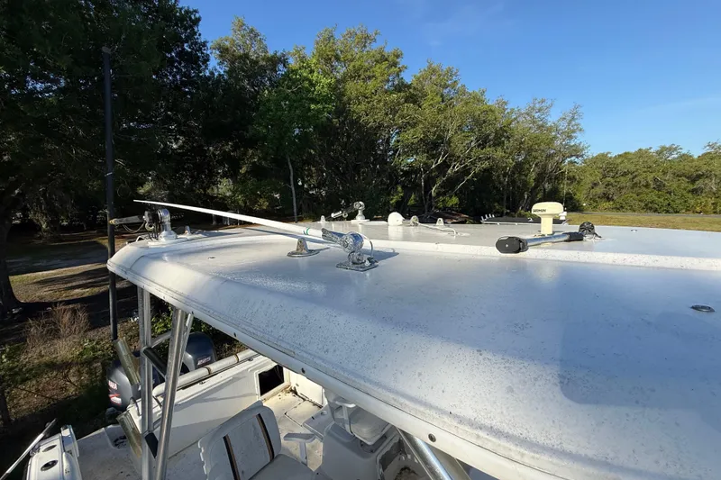 Slide: The Image of 2002 Century 2900 Walk-Around boat with fishing equipment on deck, surrounded by trees. - 71