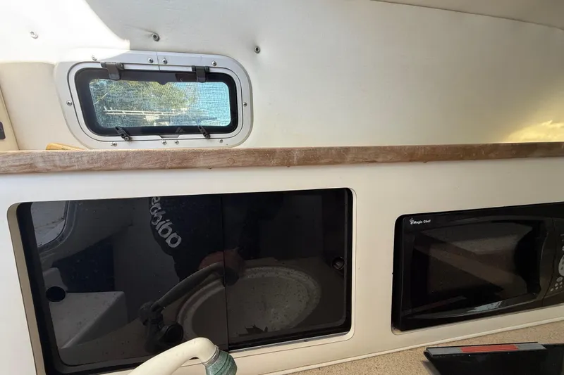 Slide: The Image of Interior of a 2002 Century 2900 Walk-Around boat with window and microwave. - 86