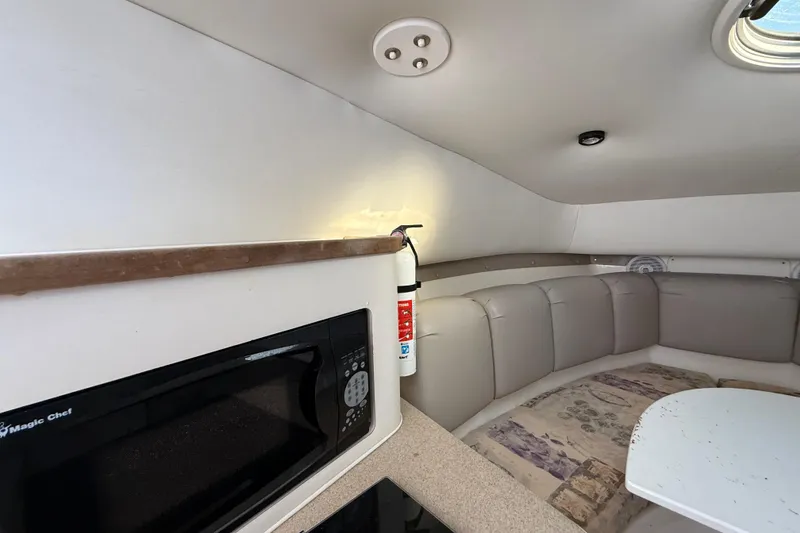 Slide: The Image of Interior of 2002 Century 2900 Walk-Around boat with seating, table, and microwave. - 87