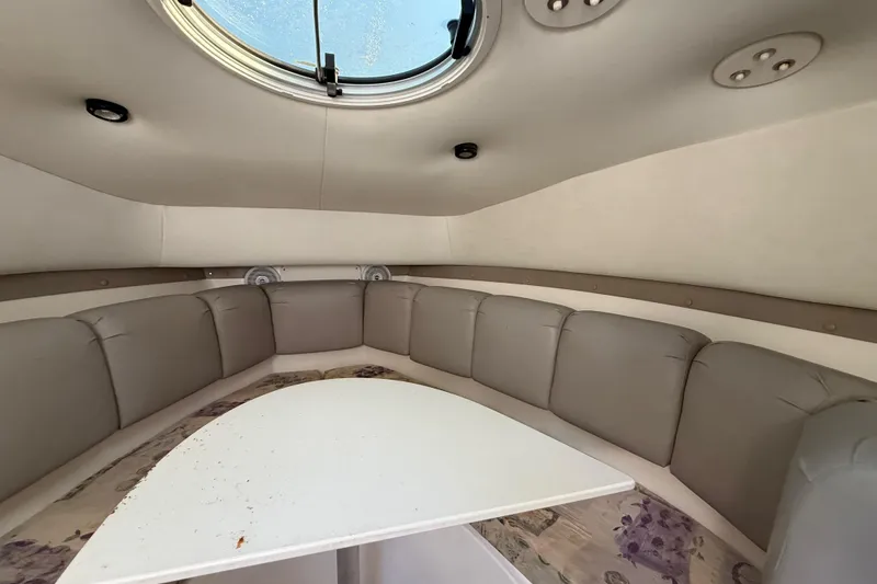 Slide: The Image of Interior of a 2002 Century 2900 Walk-Around boat with cushioned seating and table. - 89