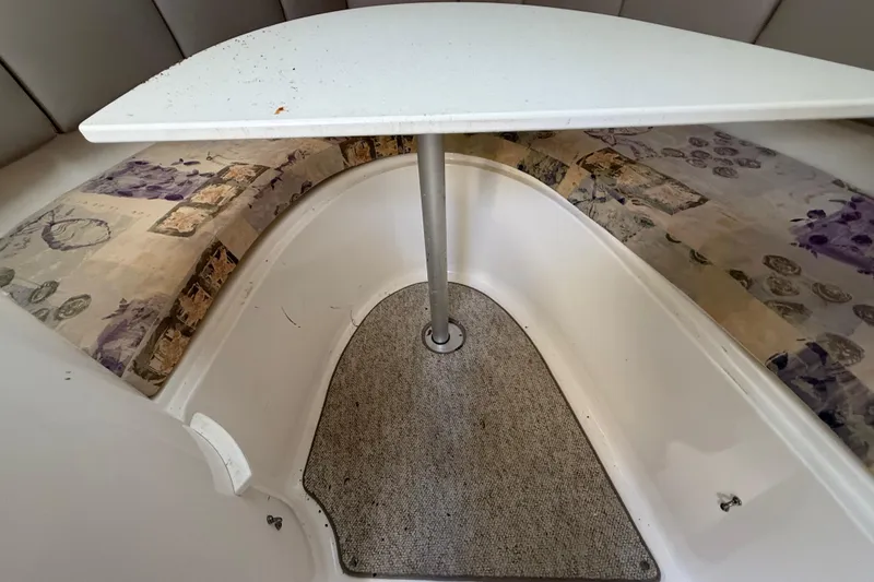 Slide: The Image of 2002 Century 2900 Walk-Around cabin interior with table and patterned seating. - 93