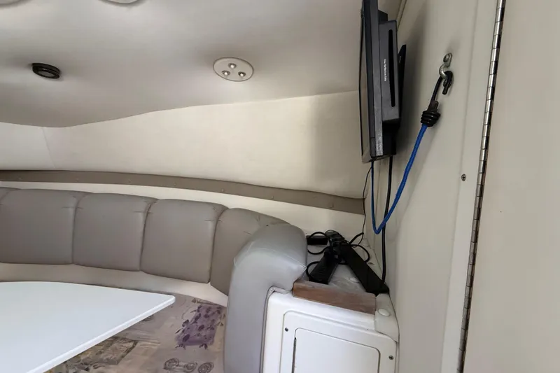Slide: The Image of Interior of a 2002 Century 2900 Walk-Around boat with seating and mounted TV. - 94