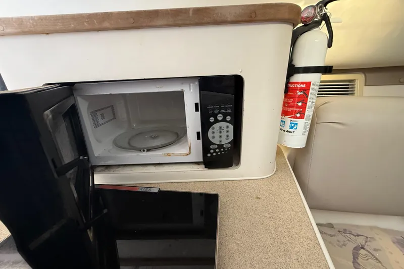 Slide: The Image of Open microwave and fire extinguisher inside 2002 Century 2900 Walk-Around boat interior. - 98