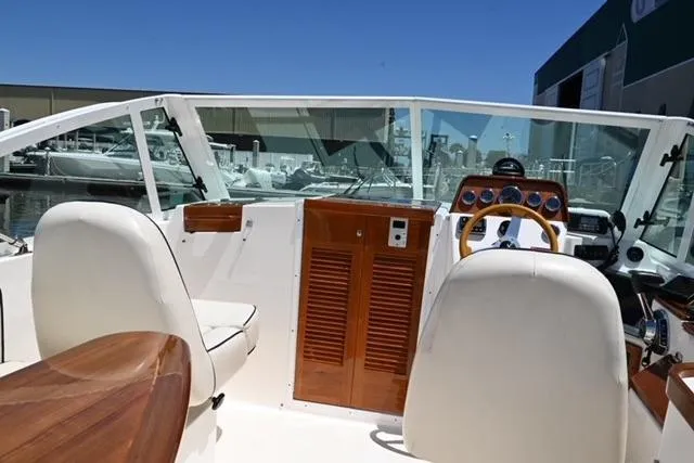 Slide: The Image of 2013 Hunt Yachts Harrier 25 interior with white seats and wooden dashboard. - 10