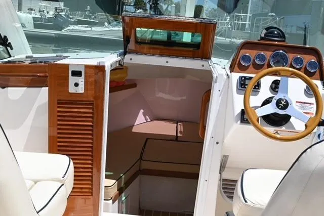Slide: The Image of 2013 Hunt Yachts Harrier 25 interior with wooden accents and steering wheel. - 12