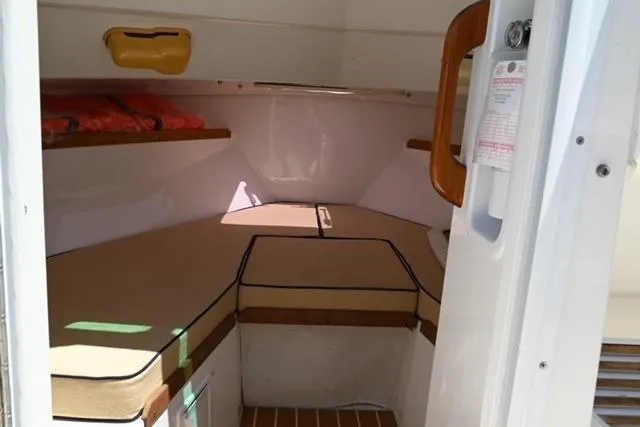 Slide: The Image of 2013 Hunt Yachts Harrier 25 cabin interior with cushioned seating and wooden accents. - 13