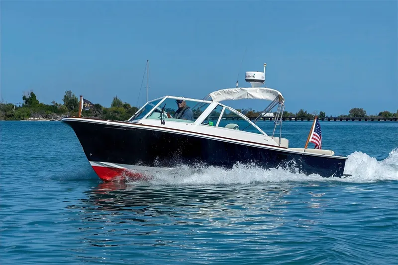 Slide: The Image of 2013 Hunt Yachts Harrier 25 cruising on blue water with American flag. - 2