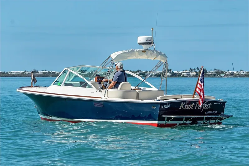 Slide: The Image of 2013 Hunt Yachts Harrier 25 boat cruising on clear blue water, American flag displayed. - 3