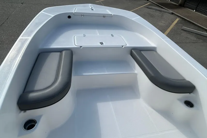 Slide: The Image of 2026 Sundance DX22 boat interior with cushioned seating and storage compartment. - 11