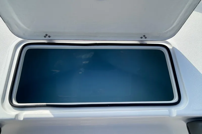 Slide: The Image of Open storage compartment on 2026 Sundance DX22 boat, showcasing interior space. - 18
